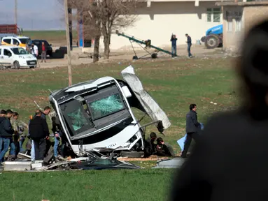 Petugas saat memeriksa kendaraan militer yang menjadi sasaran bom remote kontrol di Diyarbakir, Turki (18/2). Bom yang dikendalikan remote kontrol ini menyerang kendaraan militer dan menewaskan tujuh tentara Turki. (REUTERS / Sertac kayar)
