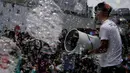 Seorang petugas meniupkan angin pada gelembung selama pertunjukan seni Bubble Up yang dibuat oleh seniman asal Jepang Shinji Ohmaki, di Hong Kong, 2 Agustus 2017. (AP Photo/Kin Cheung)