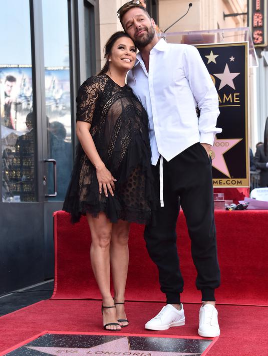 Eva Longoria dan sahabatnya, Ricky Martin berdiri di atas bintang Hollywood Walk of Fame miliknya saat acara penghargaan di Los Angeles, Senin (16/4). Eva merupakan penerima bintang ke-2.634 di kategori Televisi (Alberto E. Rodriguez/GETTY IMAGES/AFP)