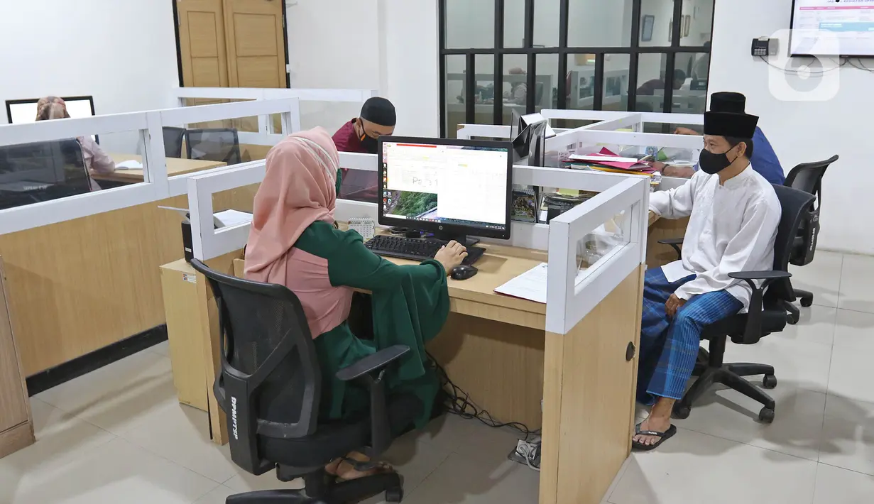 Sejumlah pegawai negeri sipil (PNS) menggunakan pakaian ala santri saat bekerja di Balai Kota Bogor, Kamis (22/4/2021). PNS di lingkungan Pemkot Bogor diwajibkan memakai pakaian ala santri setiap tanggal 22 setiap bulannya sebagai wujud penghormatan jasa para santri. (Liputan6.com/Herman Zakharia)