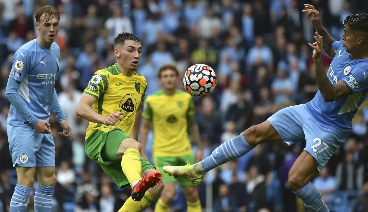 Bek Manchester City, Joao Cancelo berebut bola dengan gelandang Norwich City, Billy Gilmour pada pertandingan pekan kedua Liga Inggris di stadion Etihad di Manchester, Inggris, Sabtu (21/8/2021). Man City menang telak atas Norwich City 5-0. (AP Photo/Rui Vieira)