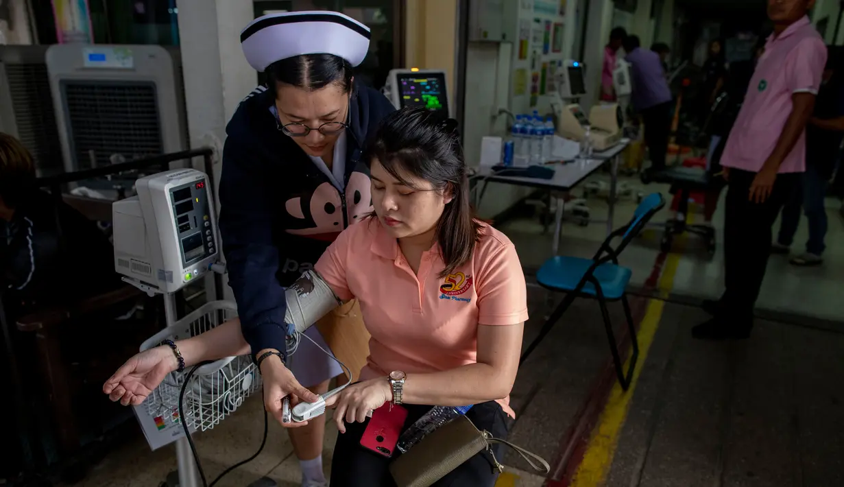 Perawat memeriksa kesehatan pendonor darah setelah penembakan brutal di Korat, Nakhon Ratchasima, Thailand, Minggu (9/2/2020). Petugas keamanan berhasil menembak mati pelaku penembakan brutal tersebut. (AP Photo/Gemunu Amarasinghe)