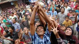 Warga berebut bungkusan gula pasir pada tradisi "Serak Gula" yang dilempar dari atas Masjid Muhammadan, Pasar Batipuh, Kecamatan Padang Selatan, Padang, Sumbar, Minggu (22/4). Tradisi ini dilakukan oleh masyarakat keturunan India yang ada di Padang pada Maulud Sahul Hamid sebagai bentuk nazar. (Antara)