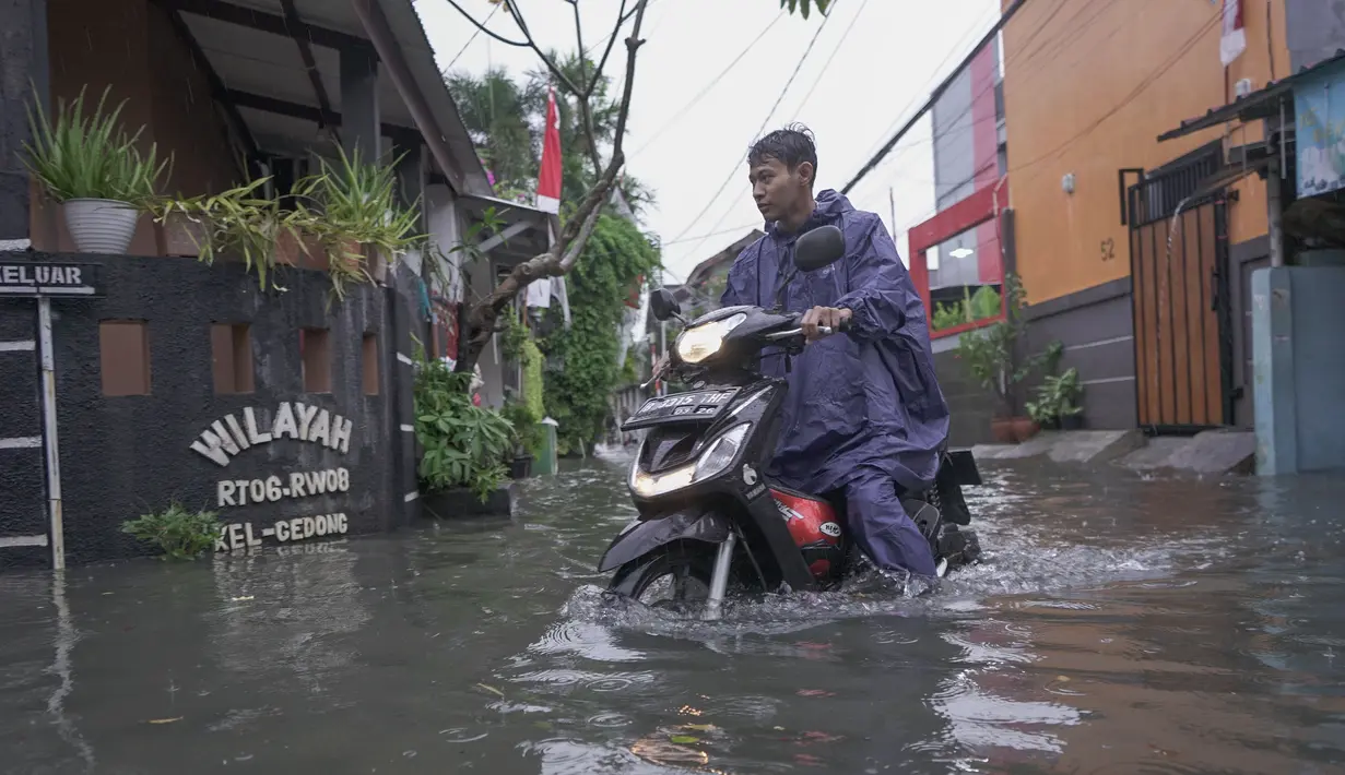 Warga melintasi genangan air di kawasan RT 10 RW 08, Kelurahan Gedong, Kecamatan Pasar Rebo, Jakarta Timur, Senin (4/8/2025). (merdeka.com/Arie Basuki)