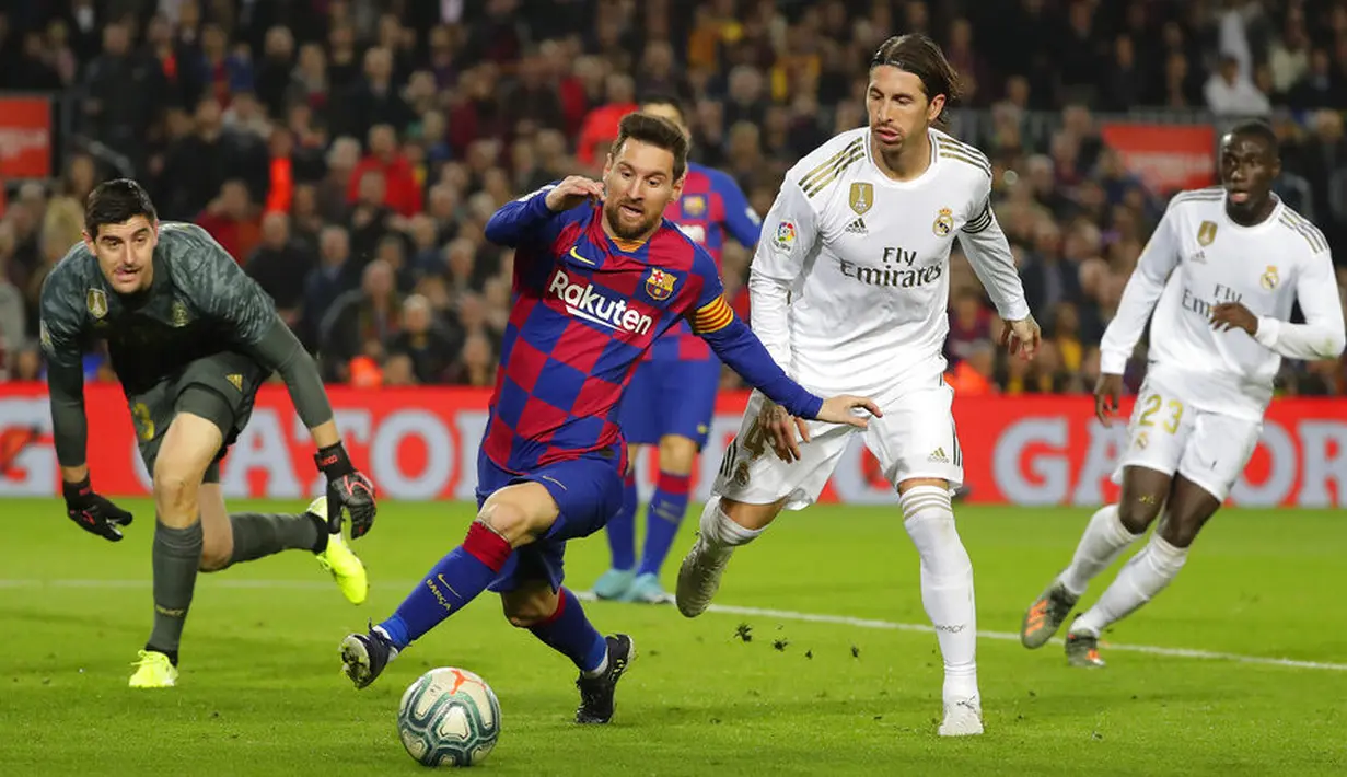 Striker Barcelona, Lionel Messi, berusaha menembus pertahanan Real Madrid pada laga La Liga 2019 di Stadion Camp Nou, Rabu (18/12). Kedua tim bermain imbang 0-0. (AP/Emilio Morenatti)