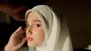 Sentuhan mahkota minimalis yang bertengger di atas hijab menambah kesan royal dan berkelas, seakan menegaskan bahwa ia adalah ratu di hari istimewanya. Riasan wajahnya pun tampil flawless, dengan nuansa soft glam yang menonjolkan kecantikannya secara alami tanpa terkesan berlebihan. [@yxsmine.ow].