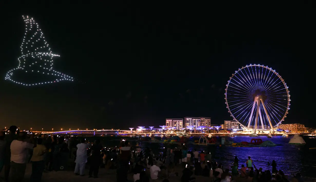 Kembang api menerangi langit selama upacara pembukaan Dubai Eye, yang dikenal sebagai Ain Dubai, di kota Emirat, dekat Dubai Marina, Kamis (21/10/2021). Bianglala terbesar dan tertinggi di dunia tersebut resmi dibuka untuk umum. (Giuseppe CACACE / AFP)