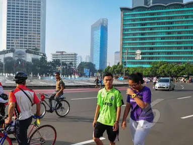Warga berolahraga di sekitar kawasan Bundaran HI, Jakarta, Minggu (19/4/2015). Beberapa warga mengaku tidak tahu jika car free day ditiadakan selama pelaksanaan Konferensi Asia Afrika (KAA). (Liputan6.com/Faizal Fanani)