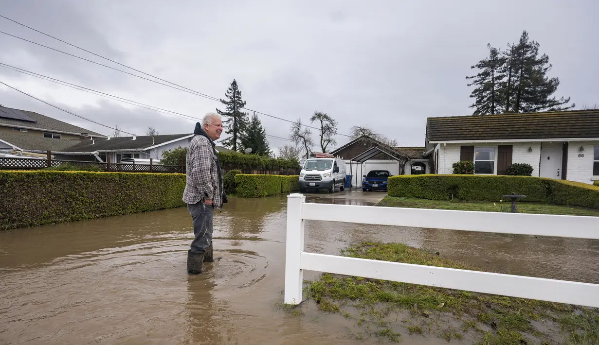 Corky Beall menyurvei banjir di College Road di Watsonville, California, Jumat, 10 Maret 2023. Di Santa Cruz County, sebuah sungai yang meluap karena hujan menghancurkan sebagian Jalan Utama di Soquel, sebuah kota berpenduduk 10.000 orang, mengisolasi beberapa lingkungan. (AP Photo/Nic Coury)