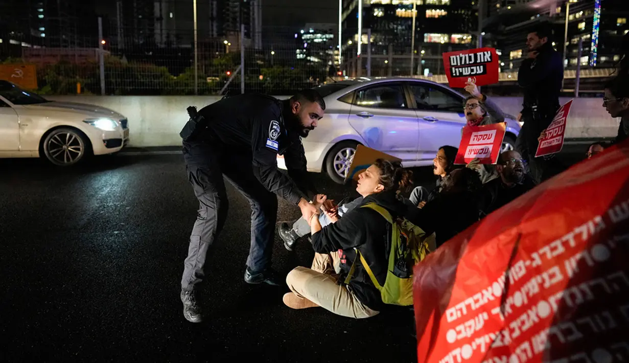 Polisi pun membubarkan para pengunjuk rasa yang memblokade jalan raya. (AP Photo/Ohad Zwigenberg)