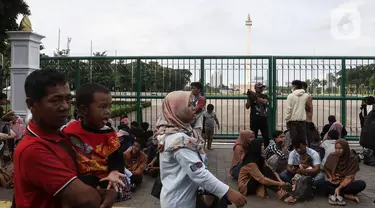 Warga memanfaatkan libur tahun baru 2023 dengan mengunjungi kawasan Monumen Masional (Monas), Jakarta, Minggu (1/1/2023). Monas menjadi salah satu destinasi wisata favorit warga baik dari Jakarta, maupun luar ibu kota, untuk menikmati liburan tahun baru. (Liputan6.com/Johan Tallo)