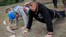 Siswa melakukan push-up saat mengikuti pelatihan di kamp paramiliter di Kiev, Ukraina, (14/7). Konflik yang terjadi di bagian timur Ukraina membuat beberapa orang tua sangat ingin memastikan anak-anak mereka siap jika perang. (AP Photo/Efrem Lukatsky)