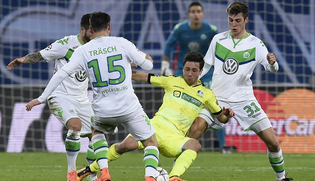 Gelandang Gent, Brecgt Dejaegere, kesulitan lolos karena diapit para pemain Wolfsburg. Dua gol Gent baru bisa tercipta pada menit ke 80 dan 89. (AFP/John Thys)