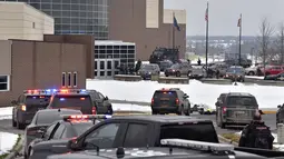 Puluhan personel polisi, pemadam kebakaran, dan EMS bekerja di lokasi penembakan di Oxford High School di Oxford, Michigan (30/11/2021). Tiga orang siswa tewas dan enam orang lainnya termasuk seorang guru terluka dalam peristiwa penembakan tersebut. (Todd McInturf/The Detroit News via AP)