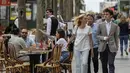 Orang-orang melintasi jalan Champs Elysees di Paris, Kamis (17/6/2021). Prancis mengumumkan melonggarkan aturan pembatasan COVID-19, mencabut aturan penggunaan masker di luar ruangan dan menghentikan jam malam mulai pekan ini setelah delapan bulan terakhir. (AP Photo/Michel Euler)