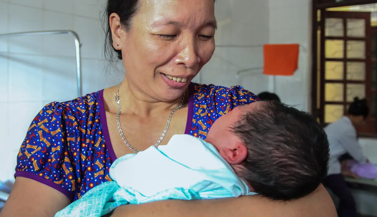 Vu Thi Thu menggendong cucunya, Tran Tien Quoc di pusat kesehatan Vinh Tuong, provinsi Vinh Phuc, Vietnam, Minggu (15/10). Bayi yang lahir dengan berat 7,1 kilogram itu pun menjadi bayi terberat di negara Asia Tenggara. (LE PHUONG/AFP)