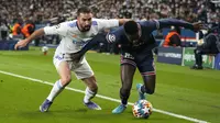 Bek Paris Saint Germain (PSG) Nuno Mendes berebut bola dengan bek Real Madrid Dani Carvajal pada leg pertama babak 16 besar Liga Champions di Stadion Parc des Princes, Rabu dini hari WIB (16/2/2022). PSG susah payah kalahkan Real Madrid 1-0. (AP Photo/Michel Euler)