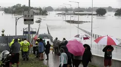 Warga menyaksikan banjir Sungai Hawkesbury di Windsor, barat laut Sydney, New South Wales, Australia (22/3/2021).  Negara bagian New South Wales yang padat penduduknya telah mengeluarkan lebih banyak perintah evakuasi menyusul banjir terburuk dalam beberapa dekade. (AP Photo/Rick Rycroft)