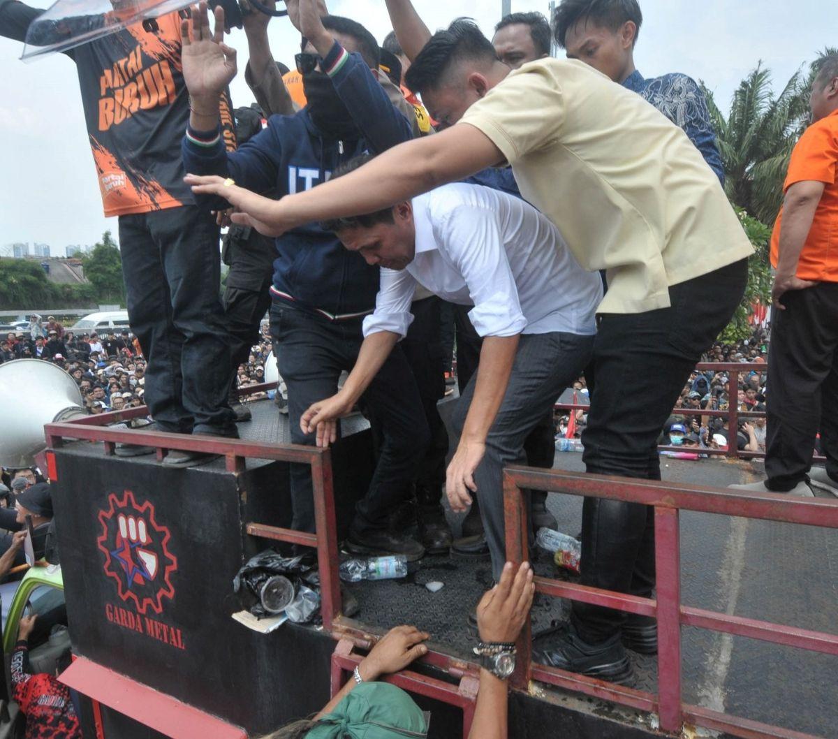 Setelah hadir menemui para demonstran tolak RUU Pilkada, anggota DPR dari Fraksi Gerindra Habiburokman tampak dilindungi sejumlah orang saat akan turun dari atas mobil komando di depan Gedung DPR, Jakarta, Kamis (22/8/2024). Foto: merdeka.com / Imam Buho