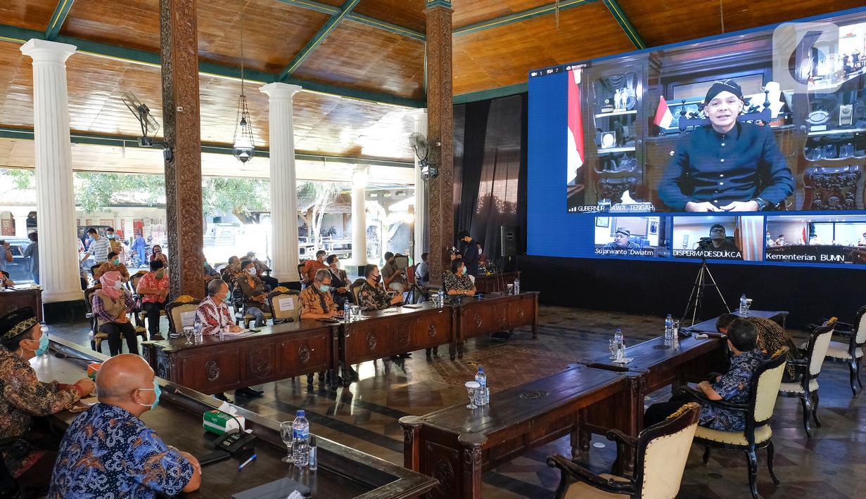 Gubernur Jawa Tengah, Ganjar  Pranowo (layar) memberikan sambutan melalui video conference pada acara Penandatangan Perjanjian Kerjasama Pendirian Perusahaan Patungan antara PT Semen Gresik dengan 6 PT BUMDes di Rembang, Kamis (9/4/2020). (Liputan6.com/Pool/SIG)