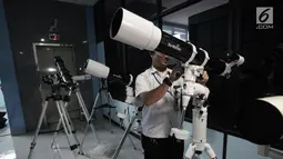 Petugas mempersiapkan teleskop yang akan digunakan untuk melihat fenomena Supermoon di Planetarium Jakarta, Selasa (30/1). Planetarium Jakarta menggelar nonton bareng fenomena Supermoon dengan menyiapkan 16 teleskop. (Liputan6.com/Arya Manggala)