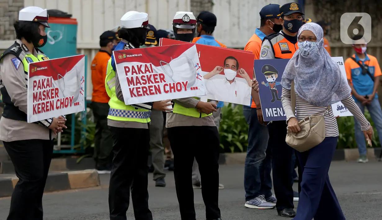 Pejalan kaki melintas saat sosialisasi penerapan protokol kesehatan PSBB di Bundaran HI, Jakarta, Minggu (13/9/2020). Kepastian pemberlakuan kembali PSBB di Jakarta masih dibahas antara Pemprov DKI dan pemerintah pusat dan akan diumumkan nanti sore. (merdeka.com/Arie Basuki)