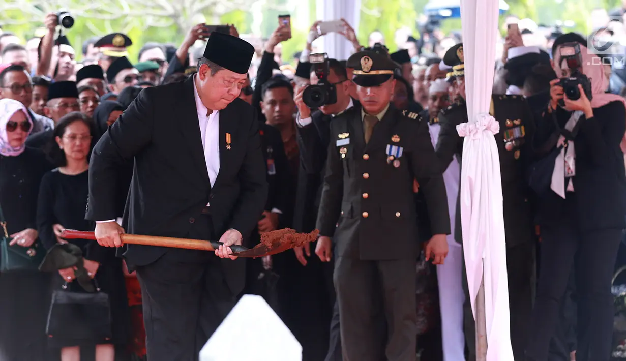 Presiden ke-6 RI Susilo Bambang Yudhoyono saat menimbun tanah ke liang lahat almarhumah Ani Yudhoyono di TMP Kalibata, Jakarta, Minggu (2/6/2019). Ani Yudhoyono meninggal dunia di National University Hospital Singapura pada 1 Juni 2019 karena kanker darah. (Fimela.com/Deki Prayoga)