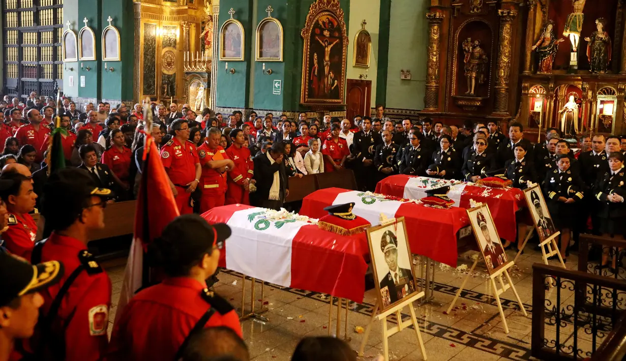 Keluarga dan rekan kerja mengahadiri upacara pemakaman di sebuah gereja di Lima, Peru (21/10). Tiga petugas pemadam kebakaran tewas saat bertugas memadamkan api di sebuah pabrik sepatu di Kota Lima. (Reuters/Guadalupe Pardo)