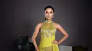 Farhana kenakan gaun halterneck kuning kunyit yang merepresentasikan budaya Lampung. Potongan rok slit dan wrapped belt bikin penampilannya terlihat anggun [@farhanariswari]