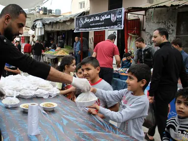 Para pekerja Palestina membagikan makanan gratis pada hari keempat Ramadan di Deir al-Balah, Jalur Gaza tengah, pada 27 April 2020. (Xinhua/Rizek Abdeljawad)
