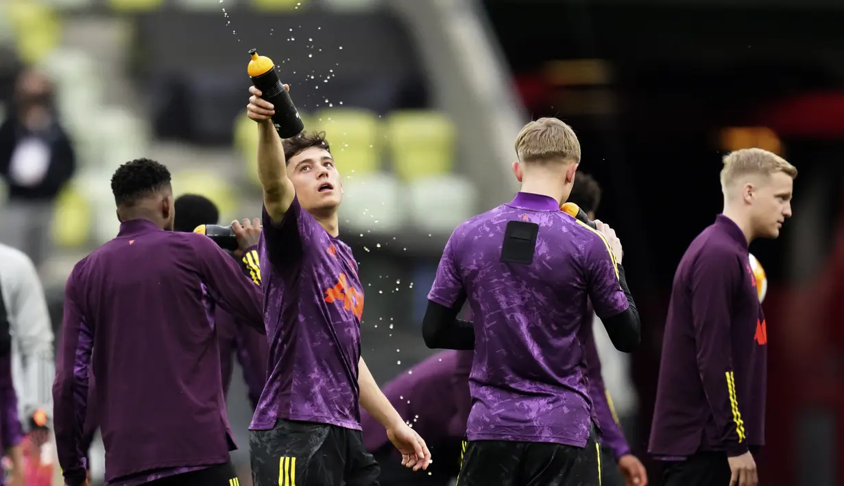 Gelandang Manchester United (MU), Daniel James menyemprotkan air saat sesi latihan menjelang final Liga Europa di Gdansk, Polandia, Selasa (25/5/2021).  Manchester United akan melakoni final Liga Europa melawan Villarreal pada Kamis (27/5) dini hari WIB. (AP Photo/Michael Sohn)