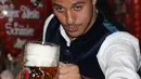 Gelandang Bayern Munchen, Thiago Alcantara berpose dengan bir selama kunjungan tahunan klub sepak bola di festival bir Oktoberfest di Munich, Jerman selatan pada 6 Oktober 2019. (AFP.Stefan Matzke)