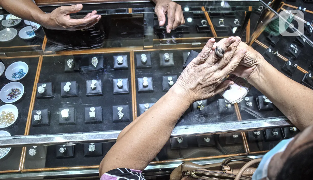 Calon pembeli mencoba cincin berlian di toko perhiasan di Pasar Rawa Bening, Jatinegara, Jakarta, Kamis (11/11/2021). Harga jual berlian mengalami penurunan mencapai 15 persen. (merdeka.com/Iqbal S. Nugroho)