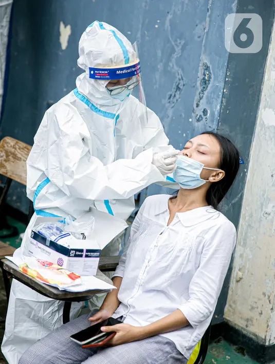 Petugas medis melakukan swab antigen terhadap pengungsi banjir di Universitas Borobudur, Cipinang Melayu, Jakarta, Minggu (21/2/2021). Swab antigen COVID-19 terhadap pengungsi dilakukan mengingat di pengungsian mereka tidur berhimpitan. (Liputan6.com/Faizal Fanani)