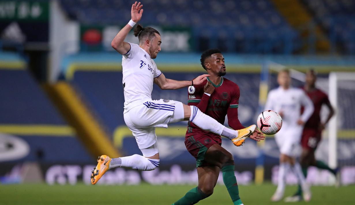 Bek Wolverhampton Wanderers, Nelson Semedo, berebut bola dengan gelandang Leeds United, Jack Harrison, pada laga Liga Inggris di Elland Road, Selasa (20/10/2020) dini hari WIB. Wolves menang 1-0 atas Leeds United. (AFP/Alex Pantling/pool)