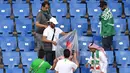 Suporter Arab Saudi memunguti sampah di tribun seusai laga melawan Uruguay pada pertandingan kedua Grup A Piala Dunia 2018 di Rostov Arena, Rostov-on-Don, Rabu (20/6). Kalah 0-1, Arab Saudi menjadi tim kedua yang tersingkir setelah Maroko (AFP/JOE KLAMAR)