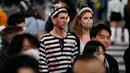Orang-orang dengan kostum berjalan menyeberangi persimpangan jalan yang terkenal saat perayaan Halloween di distrik hiburan Shibuya, Tokyo, Jepang, 31 Oktober 2022. (AP Photo/Hiro Komae)