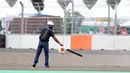 Marshal membersihkan lintasan jelang kualifikasi MotoGP di Pertamina Mandalika International Street Sirkuit, Lombok, Sabtu (19/3/2022). Paddock Marshals memastikan semua motor berada dengan benar di area perakitan, sebelum mereka menuju ke grid. (Liputan6.com/Helmi Fithriansyah)