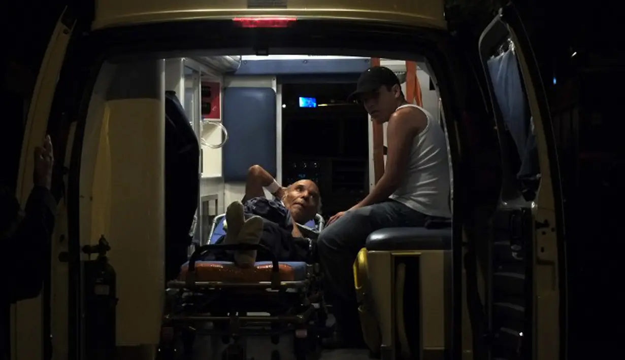Seorang lanjut usia (lansia) berada di mobil ambulans usai kebakaran di sebuah panti jompo swasta di Caracas, Venezuela, Minggu (23/8/2015) waktu setempat. Delapan orang penghuni panti tewas dalam peristiwa tersebut. (AFP PHOTO/JUAN BARRETO)