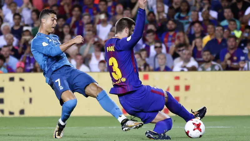 Bek Barcelona, Gerard Pique (kanan), coba menghentikan striker Real Madrid, Cristiano Ronaldo, pada leg pertama Piala Super Spanyol. Barcelona kalah agregat 1-5 dari Real Madrid. (AP/Manu Fernandez)