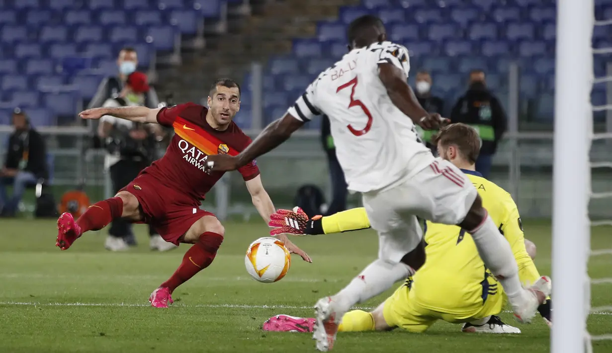 Gelandang AS Roma, Henrikh Mkhitaryan (kiri) melepaskan tendangan yang masih mampu dimentahkan kiper Manchester United, David de Gea dalam laga leg kedua semifinal Liga Europa 2020/2021 di Olimpico Stadium, Roma, Kamis (6/5/2021). AS Roma menang 3-2 atas Manchester United. (AP/Alessandra Tarantino)