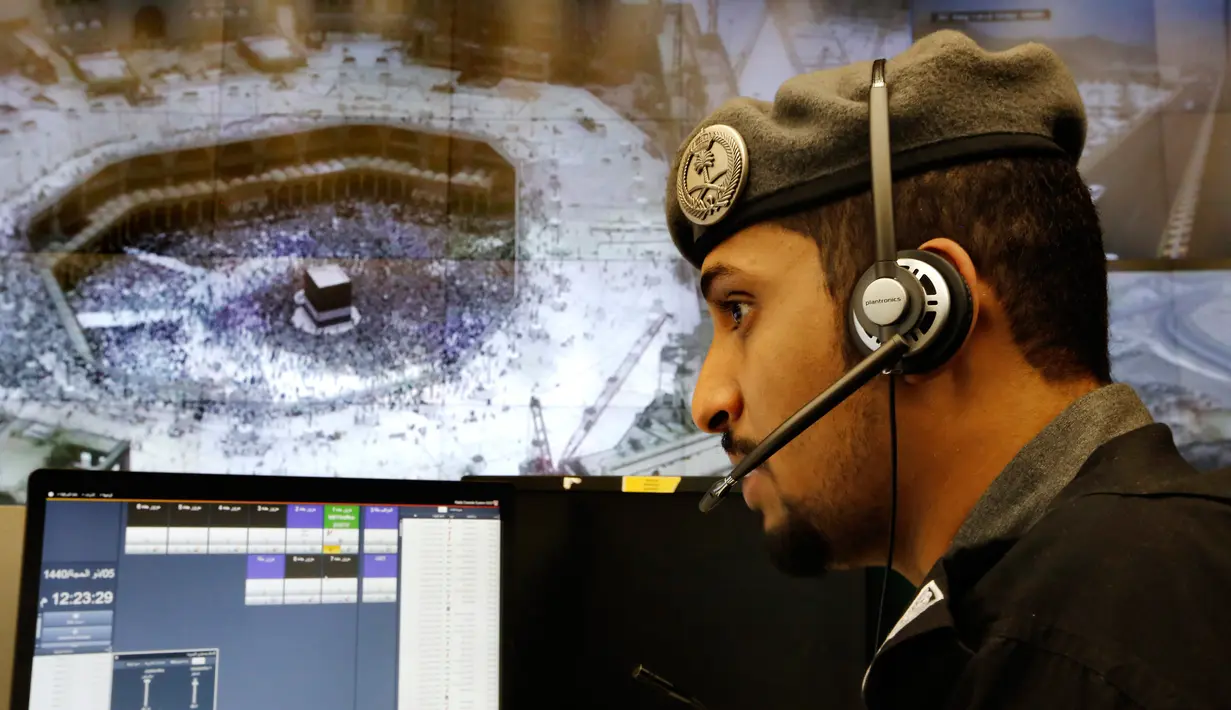 Perwira polisi Arab Saudi memantau layar yang memperlihatkan Masjidil Haram di Pusat Pemantauan 911, Makkah, Selasa (6/8/2019). Pusat Pemantauan 911 memantau melalui 5.900 kamera di Kota Makkah. (AP Photo/Amr Nabil)