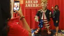 Seorang perempuan berfoto dengan patung emas Donald Trump pada Konferensi Politik Konservatif (CPAC) di Orlando, Florida, Jumat (26/2/2021). Kemunculan patung emas yang lebih besar dari ukuran pria dewasa di acara tersebut menjadi viral. (Sam Thomas/Orlando Sentinel via AP)