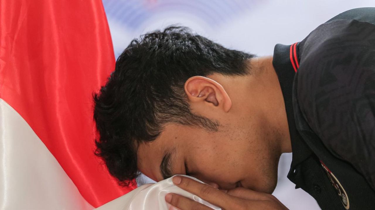 Pemain Timnas Bola Voli Putra Indonesia, Doni Haryono mencium bendera merah putih saat pelepasan Timnas Bola Voli Indonesia.