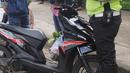 Anggota Satlantas Polres Tangerang Selatan memeriksa kelengkapan surat saat razia pajak kendaraan di Jalan BSD, Tangerang Selatan, Kamis (24/1). Razia juga untuk meningkatkan tertib lalu lintas dan disiplin pengendara bermotor. (Merdeka.com/Arie Basuki)