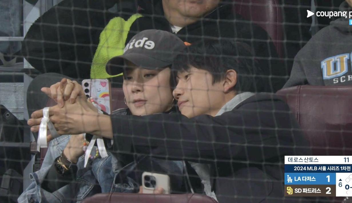 Momen tersebut rupanya tertangkap kamera. Pasangan yang sudah 10 tahun menikah ini tampak mengatur posisi gelang mereka sebelum menjepret dengan kamera ponsel. (Foto: Coupang Play via X)