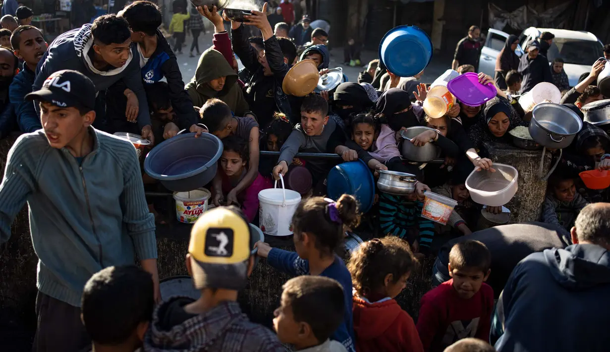 Warga Palestina berdesakan mengantre untuk mendapatkan makanan gratis di Rafah, Jalur Gaza, pada Selasa, 12 Maret 2024. (AP Photo/Fatima Shbair)
