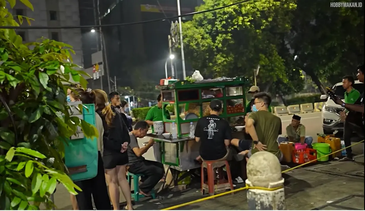 <p>Mama Rieta makan di pinggir Jalan. (Youtube/Hobby Makan)</p>