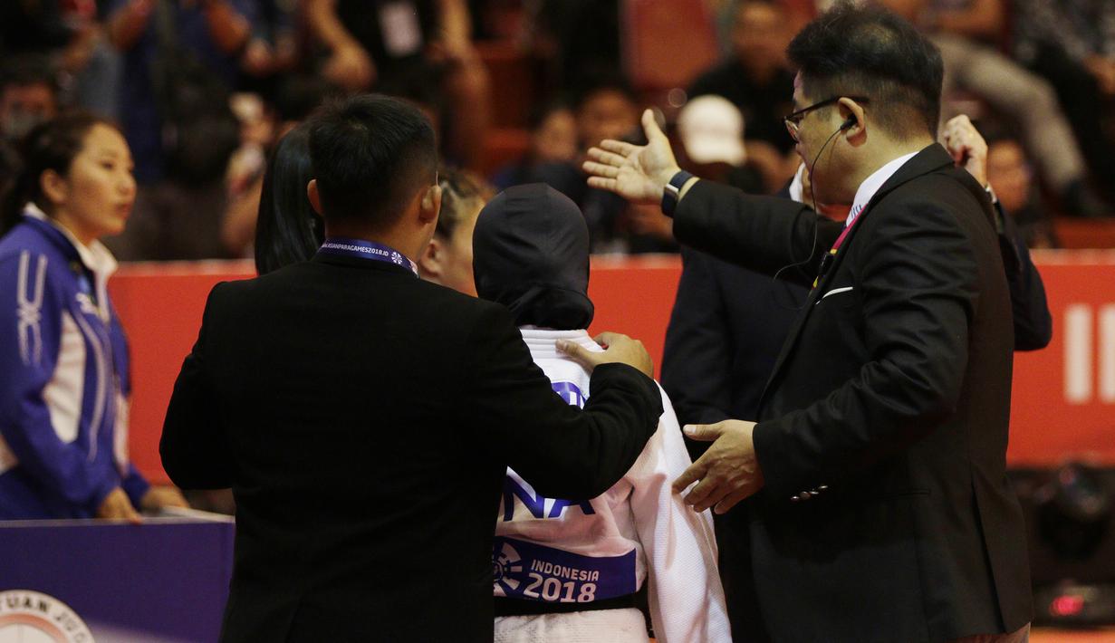 Atlet Judo Indonesia, Miftahul Jannah, meninggalkan lokasi pertandingan usai gagal berlaga pada Asian Para Games di Jiexpo, Kemayoran, Jakarta, Senin (8/10/2018). Miftah didiskualifikasi karena enggan melepas hijab nya. (Bola.com/M Iqbal Ichsan)
