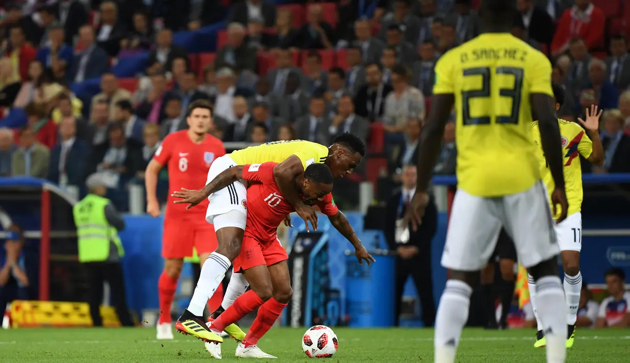 Pemain timnas Inggris, Raheem Sterling berebut bola dengan bek Kolombia, Yerry Mina pada babak 16 besar Piala Dunia 2018 di Stadion Spartak, Selasa (3/7). Sterling menjadi bahan pembicaraan setelah tertangkap kamera menggendong Mina (AFP/YURI CORTEZ)